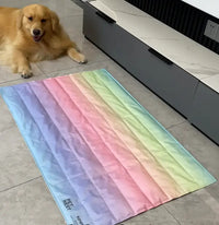 Dog sitting next to a colorful striped mat on a tiled floor.